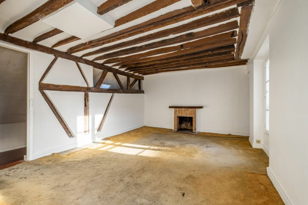 Studio avec poutres apparentes et cheminée vendu rue Charles V, Paris 4e, par Valeur Immo Paris